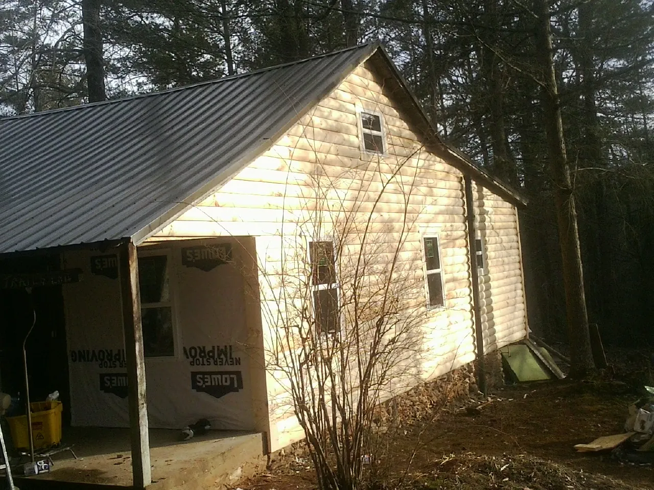 Log siding gable end under a dark metal roof edge in Riverdale